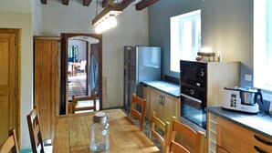 A compact kitchen with wooden cabinets, a built-in microwave, and a stove. - Le Moulin De Lombraud (Brantome En Perigord)