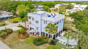 A multi-story house with a pool, surrounded by lush greenery and other residential buildings. - 3800 Cameron Boulevard Avantstay Pool, Ocean Views, Deck (Isle of Palms)
