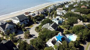 An aerial view of a residential area with houses, a beach, and a swimming pool. - 12 Dunecrest Lane by Avantstay 2 Mins to Beach w/ Pool & BBQ (Isle of Palms)