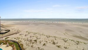 A beach with a sandy area, a wooden fence, and a clear sky. - 519 Seascape by Avantstay Shared Pool + Views, Incredible Interior Design (Isle of Palms)