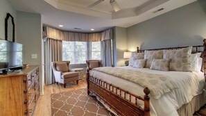 A bedroom with a large bed, a TV, a chair, and a dresser. - 73 Grand Pavilion by Avantstay Corner Lot, Porch (Isle of Palms)
