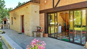 Un bâtiment moderne avec une façade en pierre, de grandes portes vitrées et un intérieur aux couleurs vives.