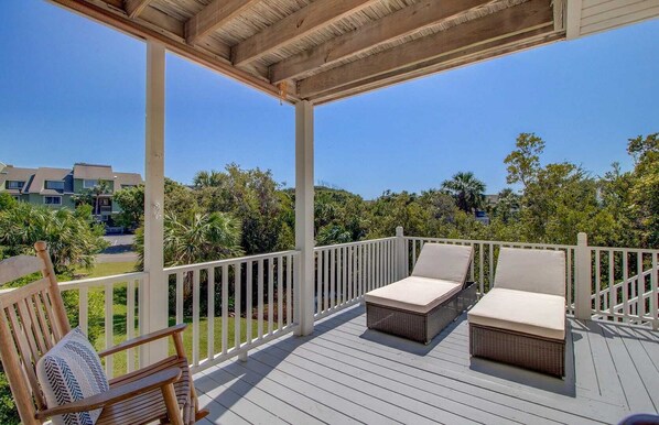 Relax on the covered deck with comfortable lounge chairs and take in the serene views of the lush landscape.