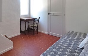 A room with a bed, a desk, and a chair.