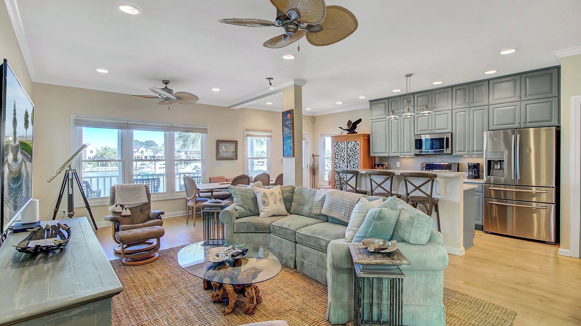 A spacious living room with a large sectional sofa, a glass coffee table, and a dining area with chairs.
