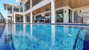 A modern hotel with a large outdoor pool, multiple balconies, and a covered outdoor seating area. - 3 47th Avenue by Avantstay Oceanfront + Private Pool + View (Isle of Palms)