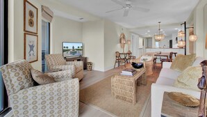 Un salon spacieux comprenant un canapé, des fauteuils, une table basse et un coin repas avec une table et des chaises.