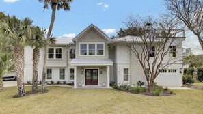 A two-story house with a front porch, a garage, and a well-maintained lawn.