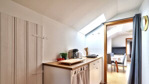 Een compacte keuken met een houten aanrecht, een koffiezetapparaat en een klein plantje.