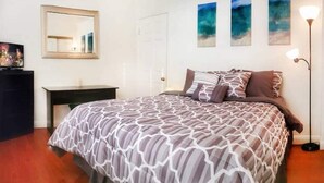A bedroom with a bed, a dresser, a desk, and a lamp. - Panoramic Strip Views ~ Spacious, Gorgeous Home! (Las Vegas)