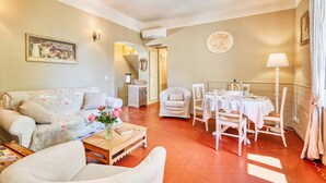 Un salon comprenant un canapé, des fauteuils, une table basse et un coin repas avec une table et des chaises.