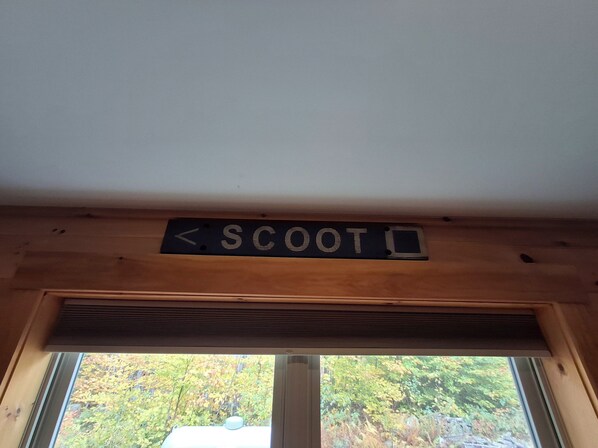 Un soffitto in legno con un cartello che indica un'area di parcheggio per scooter.