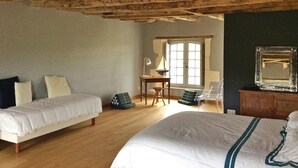 A bedroom with a wooden ceiling, a bed, a desk, and a chair.