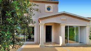 A building with a covered entrance, a large window, and a small circular window above the door. - Awesome home in Cours De Pile (Cours De Pile)