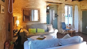Une pièce confortable avec un lit, une chaise, une petite table et une lampe.