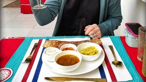 A dining table with a meal set, including bowls of rice, curry, and a glass of orange juice. - The Royal Hermitage (Jaipur)