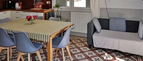 Una cocina moderna con una mesa de comedor, sillas y un sofá.
