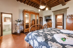 Une chambre à coucher avec un lit, une armoire en bois et un téléviseur.