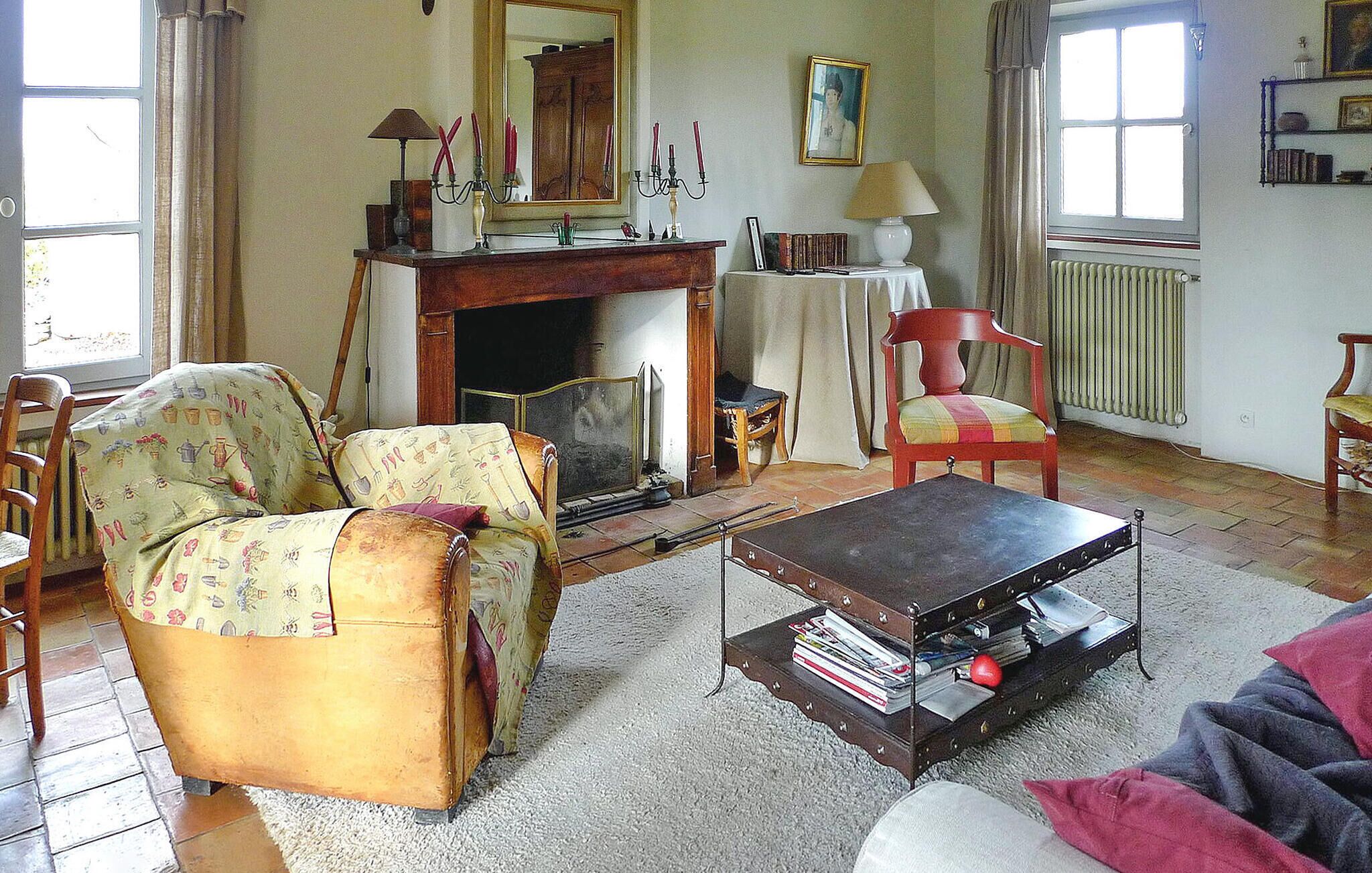 Una sala de estar acogedora con chimenea, un sofá, un sillón y una mesita de centro.