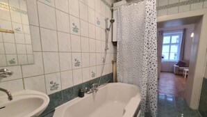 Kylpyhuone, jossa on kylpyamme, kaksi pesuallasta ja suihku.