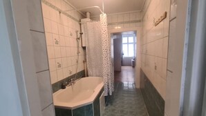 Kylpyhuone, jossa on kylpyamme, suihku ja verho.