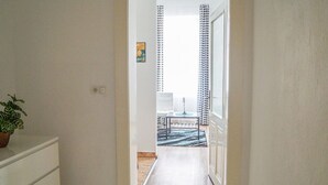 Un pasillo que conduce a una habitación con cama, una mesa y una silla.
