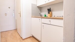 A kitchen with white cabinets, a wooden countertop, and a sink.