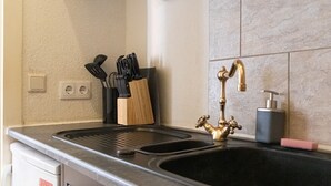 Une cuisine équipée d’un évier, d’un bloc à couteaux et d’un robinet.