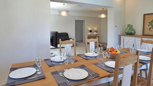A dining area with a wooden table set for four, including plates, cutlery, and wine glasses. - Pet friendly home in Moulès (Moulès)
