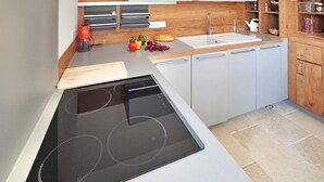 A modern kitchen with a built-in stove, a sink, and wooden cabinets. - Pet friendly home in Moulès (Moulès)