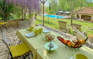 Enjoy a meal al fresco in our outdoor dining area, surrounded by a swimming pool and a gazebo.