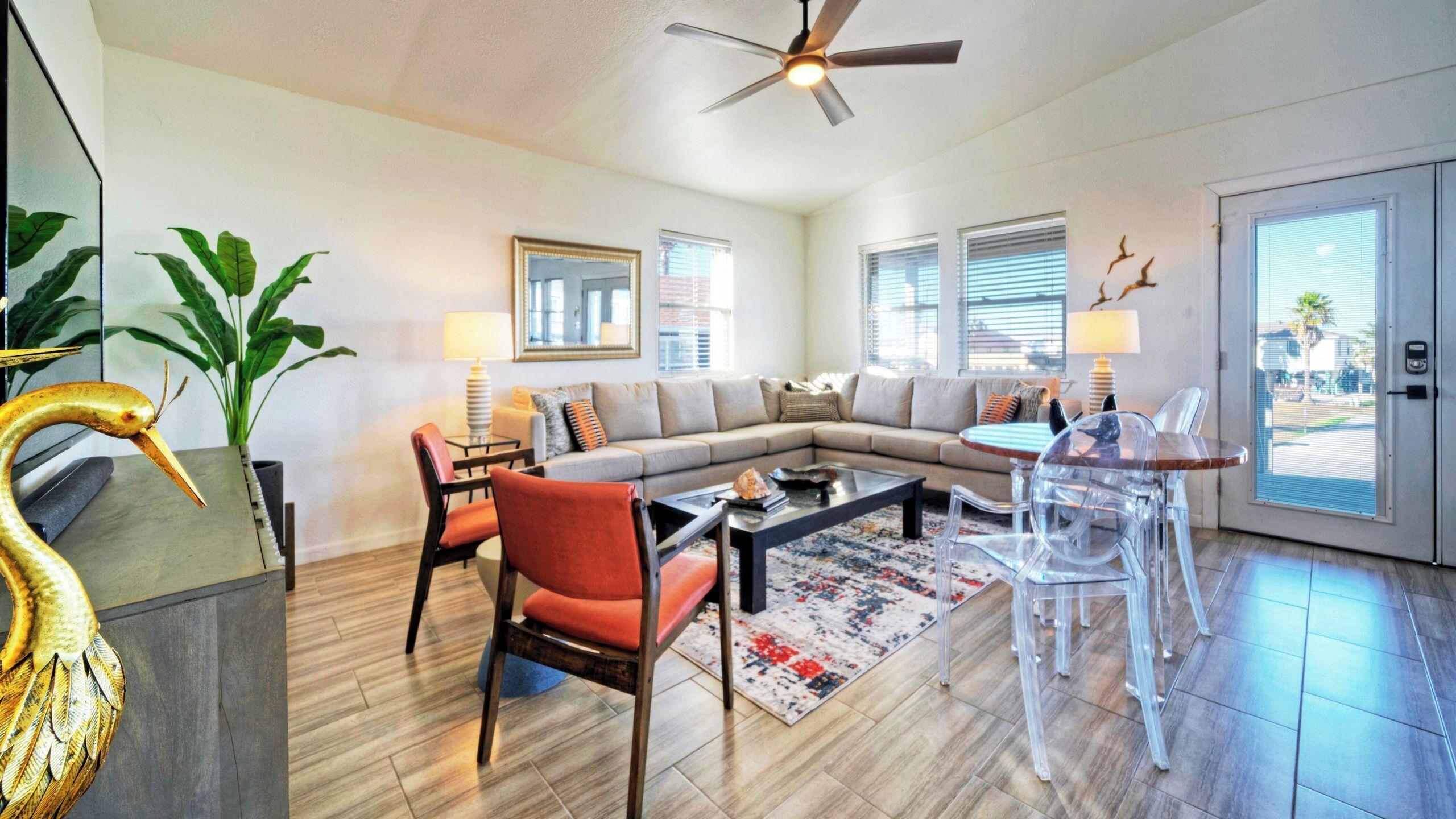 A modern living room with a sectional sofa, a coffee table, and a dining area with chairs.
