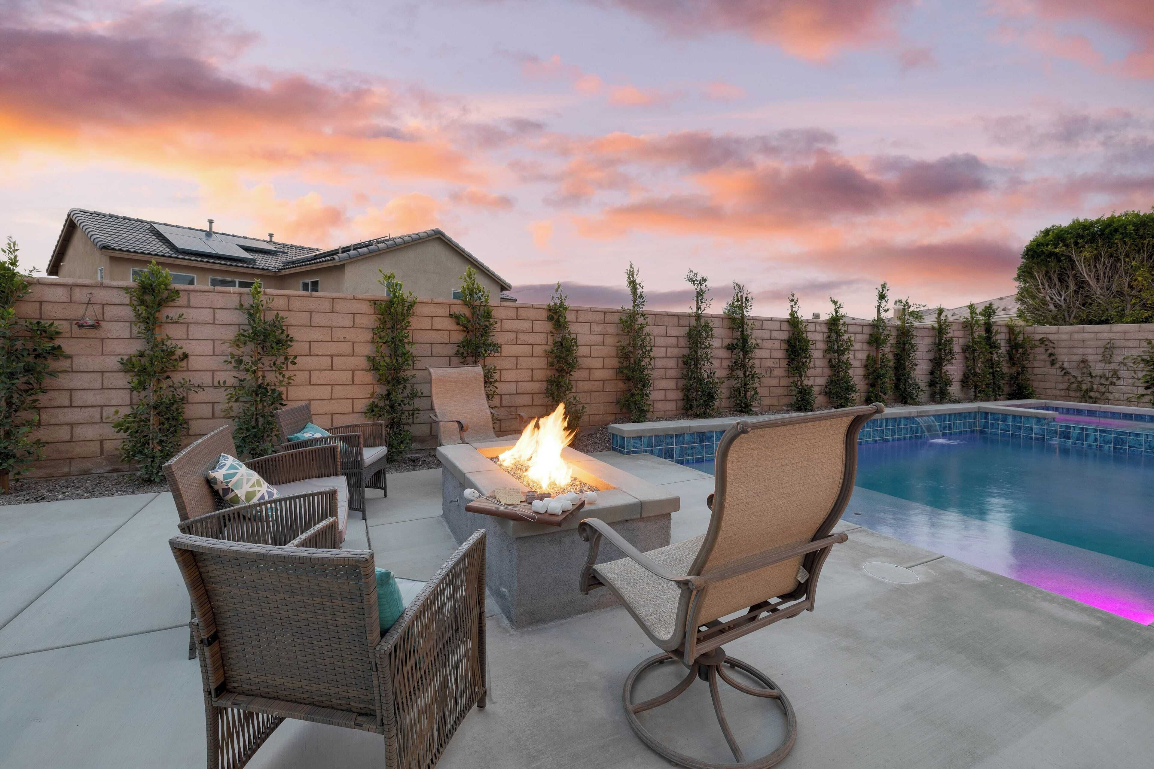 Un jardin avec un foyer extérieur, du mobilier de jardin et une piscine.