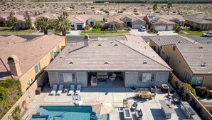 A residential area with houses featuring red-tiled roofs, a swimming pool, and outdoor seating areas. - Gated Terra Lago Escape With Private Pool, Hot Tub, Outdoor Kitchen and Lounge (Indio)