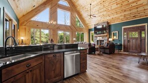 A spacious kitchen with a large island, wooden ceiling, and a stone fireplace. - Luxe Lakefront Retreat w/ Pool, Hot Tub, Theater & Private Dock Sleeps 20+ (Sherrills Ford)