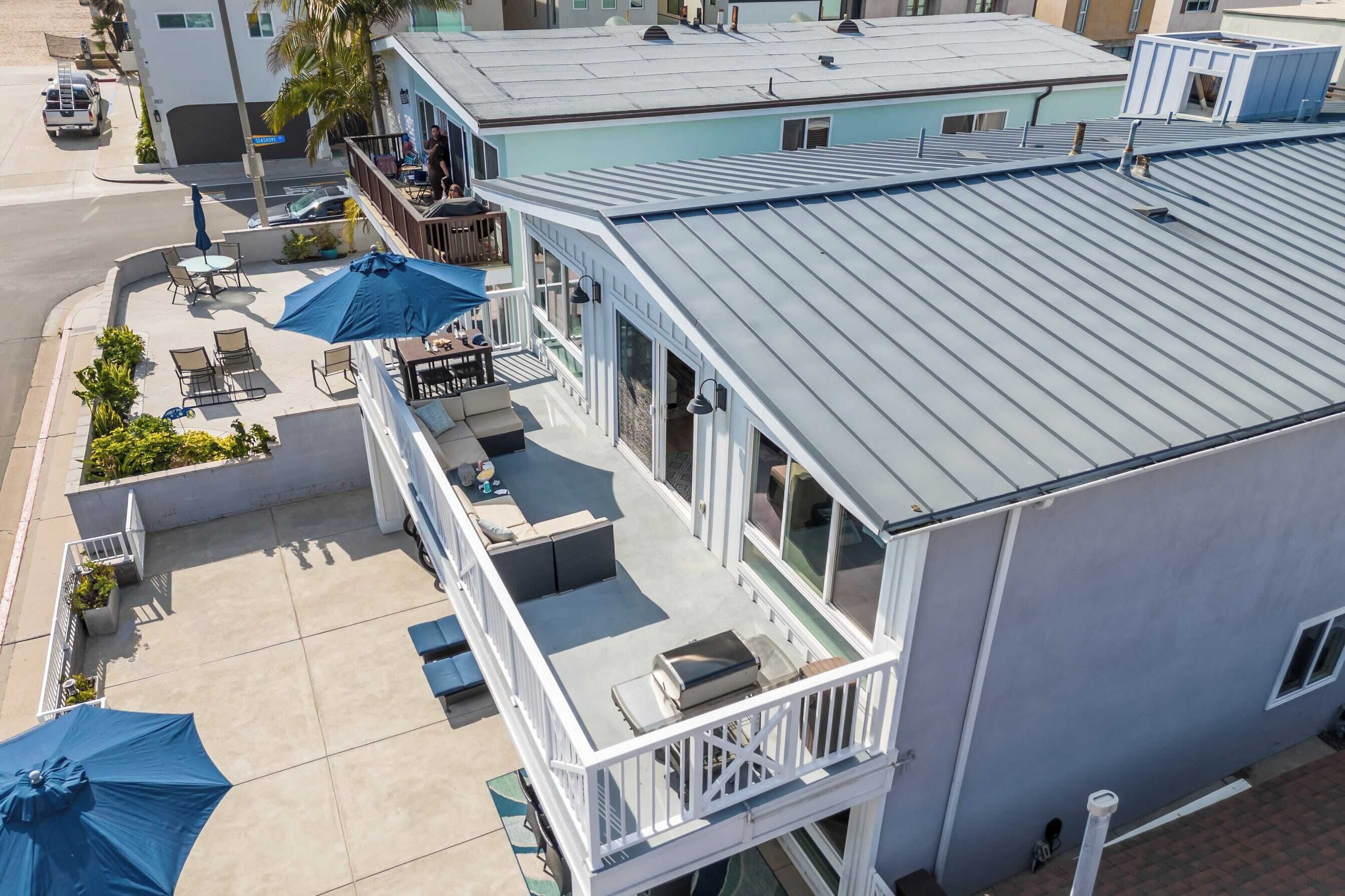 A hotel with a rooftop terrace featuring outdoor seating and umbrellas.