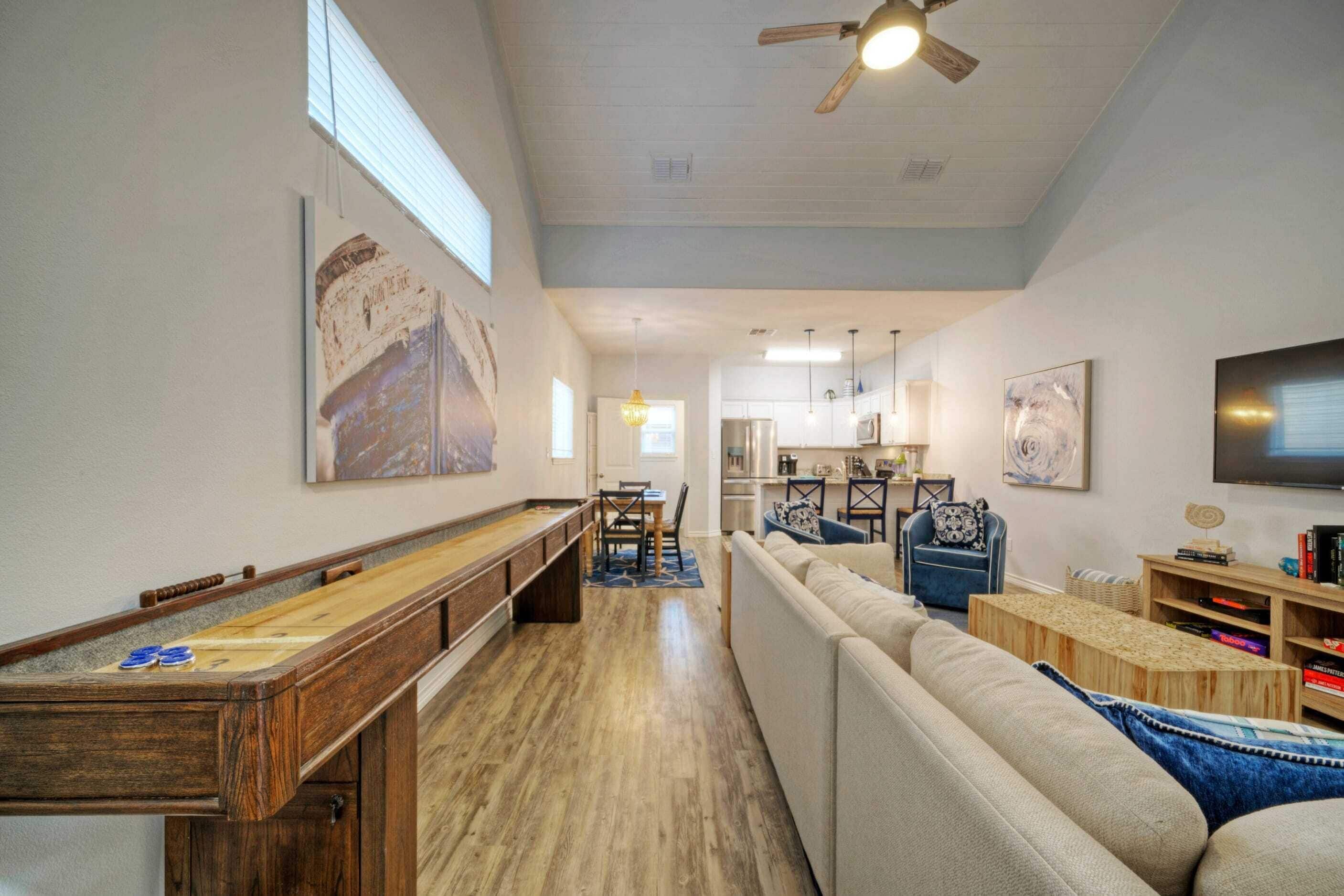 A spacious living area with a pool table, a sofa, and a television.