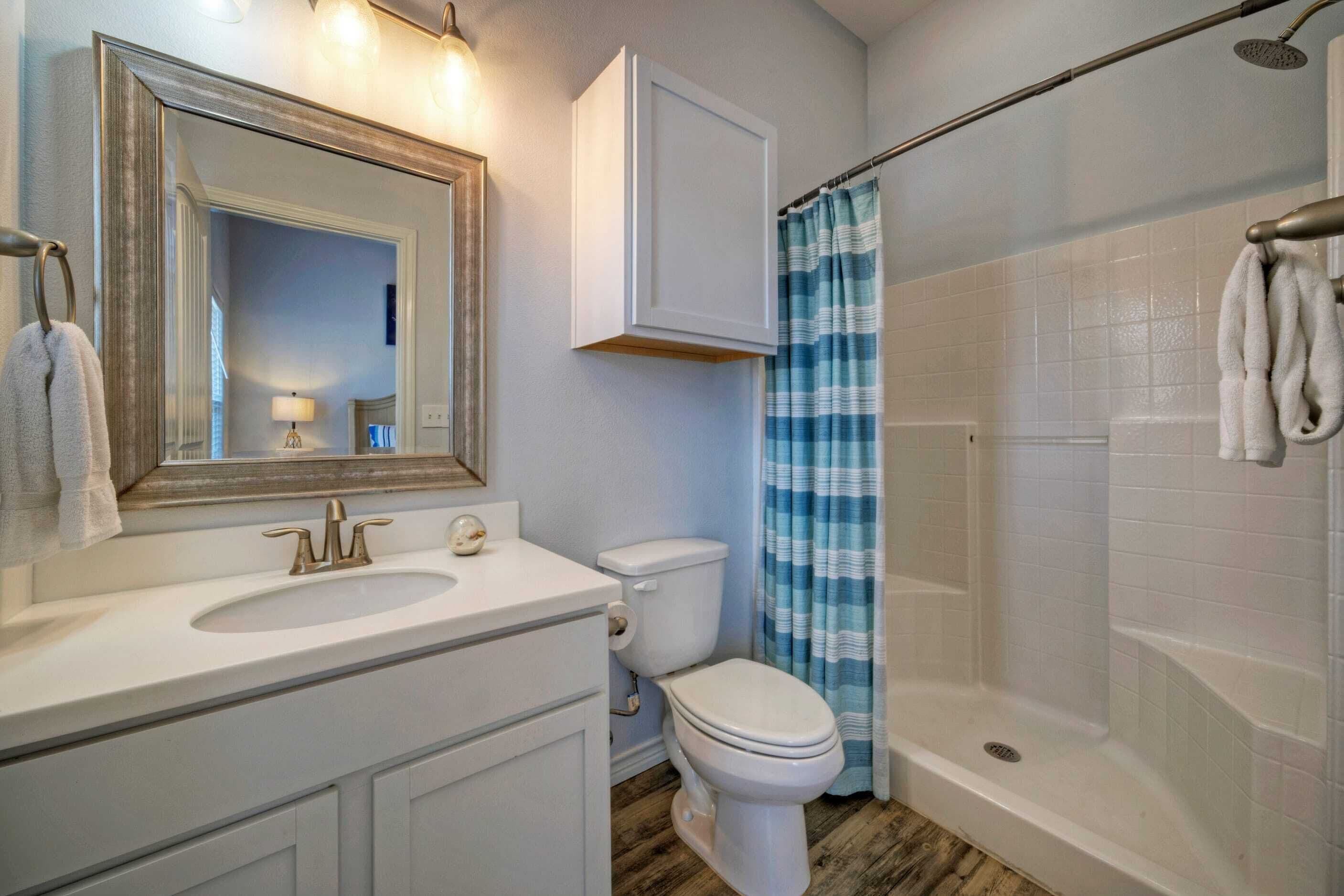 A bathroom with a sink, toilet, and shower.