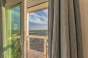 Enjoy a room with a balcony offering a view of the surrounding landscape, a seating area, and a window for natural light.