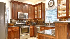 A kitchen with wooden cabinets, stainless steel appliances, and a granite countertop.