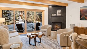 A modern living room with a fireplace, large windows, and a cozy seating area. - Riverside Getaway | Walk to Main St, Festival & Ski Fun (Telluride)