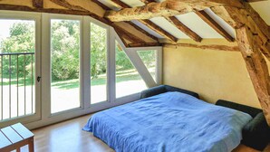 A bedroom with a bed, a small table, and a sliding glass door leading to an outdoor area. - Beautiful home in Lamonzie Montastruc (Lamonzie Montastruc)