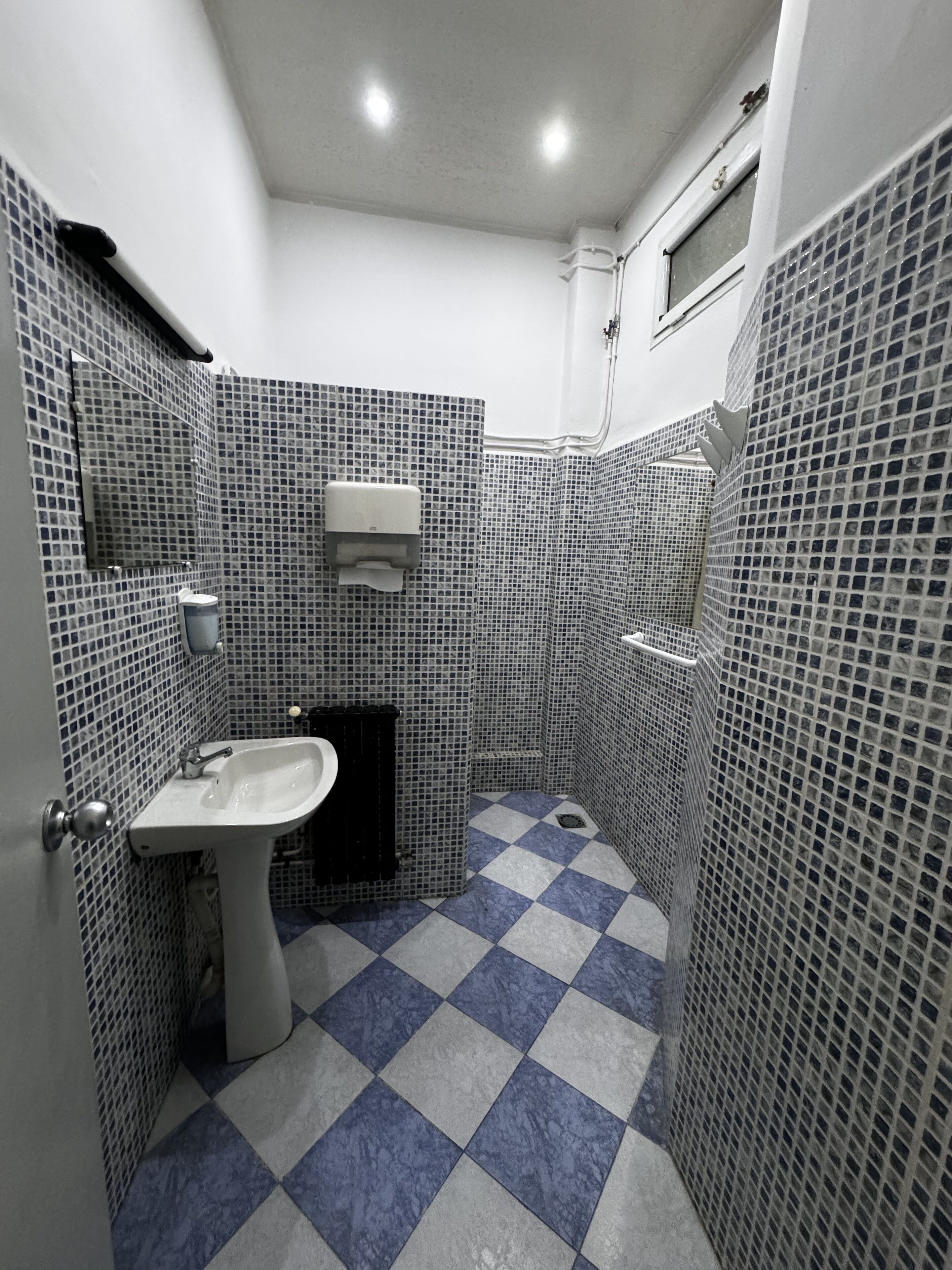 Un bagno piccolo con lavandino, specchio e pareti piastrellate.