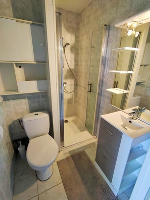 Un baño con inodoro, ducha y lavamanos.