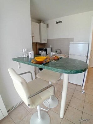 Enjoy meals in this compact kitchen with a dining table for two, complete with a refrigerator, microwave, and sink.