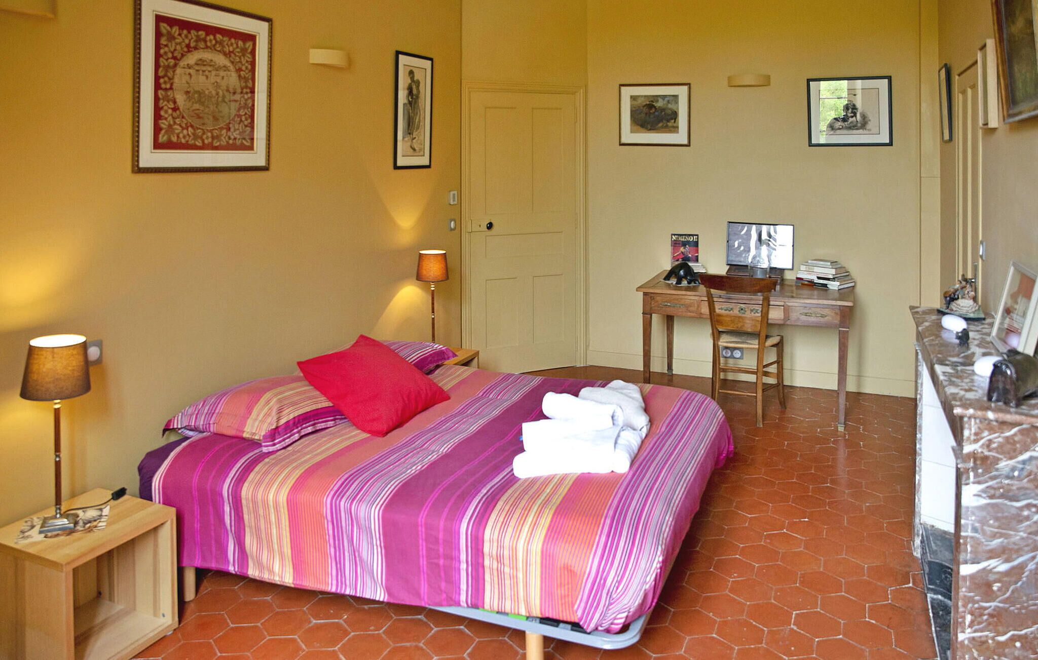 A hotel room with a bed, a desk, and a chair.