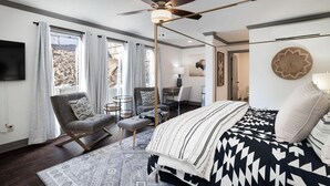 A modern bedroom with a bed, a desk, a chair, and a ceiling fan. - Park House on Main (Parkville)
