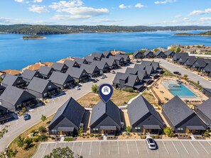 A resort with multiple chalet-style buildings, a parking lot, and a swimming pool. - Lakehouse Close to Branson with Free Tickets, Modern Kitchen & High-End Furnishings (Hollister)
