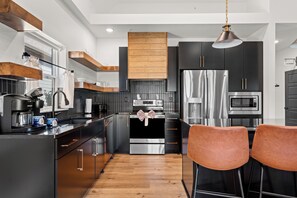 A modern kitchen with stainless steel appliances, wooden accents, and a central island. - Lakehouse Close to Branson with Free Tickets, Modern Kitchen & High-End Furnishings (Hollister)