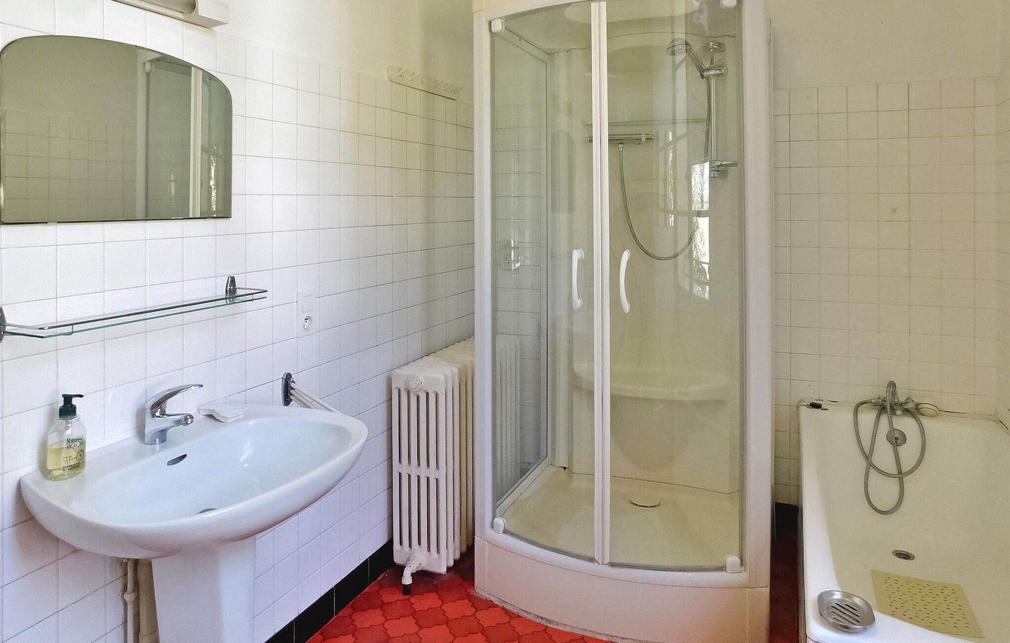 A bathroom with a white sink, a glass shower enclosure, and a bathtub.